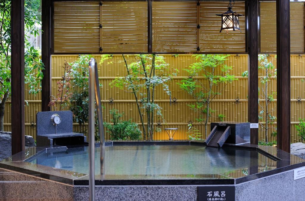 uma mesa de vidro com duas cadeiras em frente a um edifício em New Welcity Yugawara em Atami
