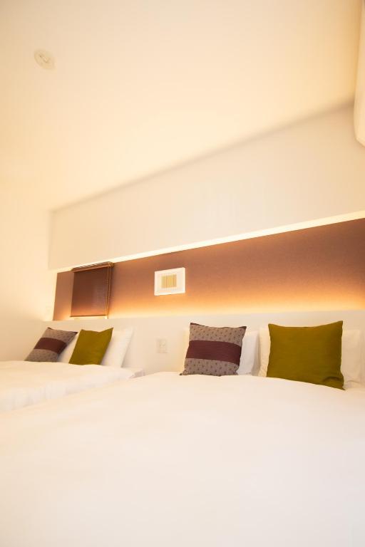 Postel nebo postele na pokoji v ubytování Apartment Hotel Tenjin TUMUGU