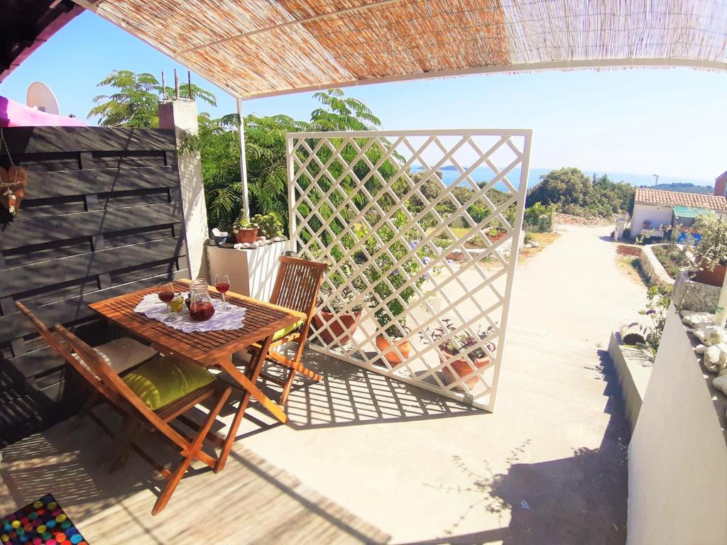 un patio con tavolo, sedie e una recinzione di Apartment Svetac - beautiful sea and islands view a Rogoznica (Rogosnizza)