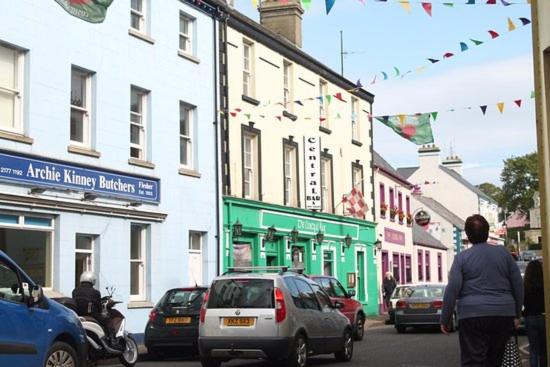 a city street with cars parked on the street at Central Bar Guesthouse in Cushendall