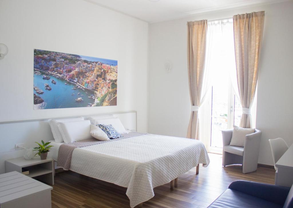 ナポリにあるルームズ スタツィオネ チェントラーレの白いベッドルーム(ベッド1台、大きな窓付)