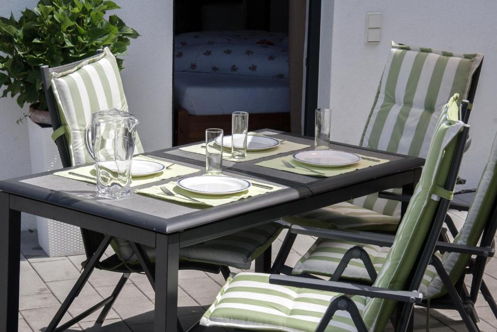 a table with two chairs with plates and glasses on it at Ferienwohnung Heissl in Fieberbrunn