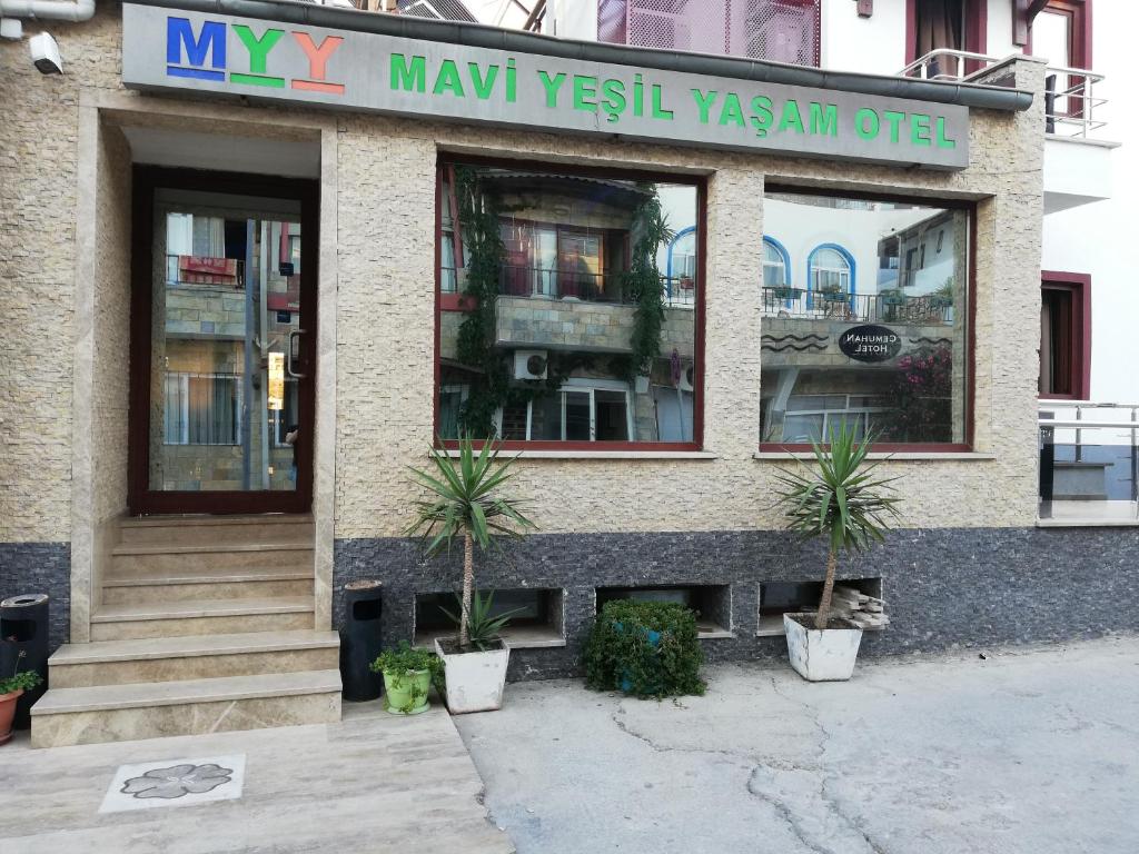 un edificio con dos macetas delante de él en Mavi Yeşil Yaşam Hotel, en Gümbet