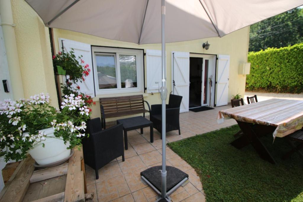 une terrasse avec un parasol, une table et des chaises dans l'établissement Toupinat, à Montferrier