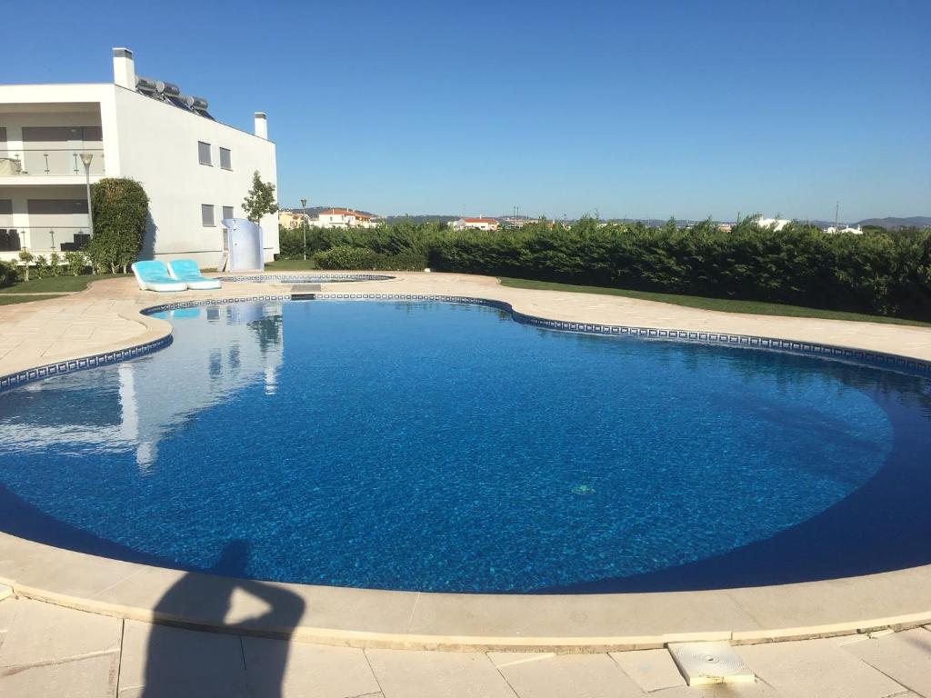 uma grande piscina azul em frente a um edifício em OLHOS DE AGUA em Roja- Pé