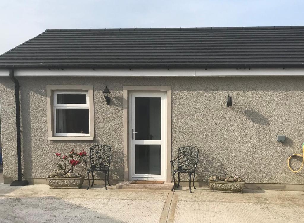 two chairs sitting in front of a house at Annslea in Lisburn