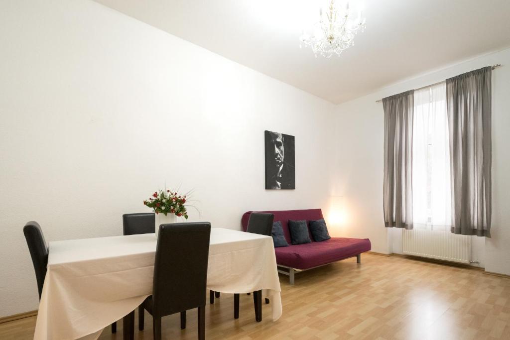 a dining room with a table and a purple couch at Tulpen Residenz in Offenbach