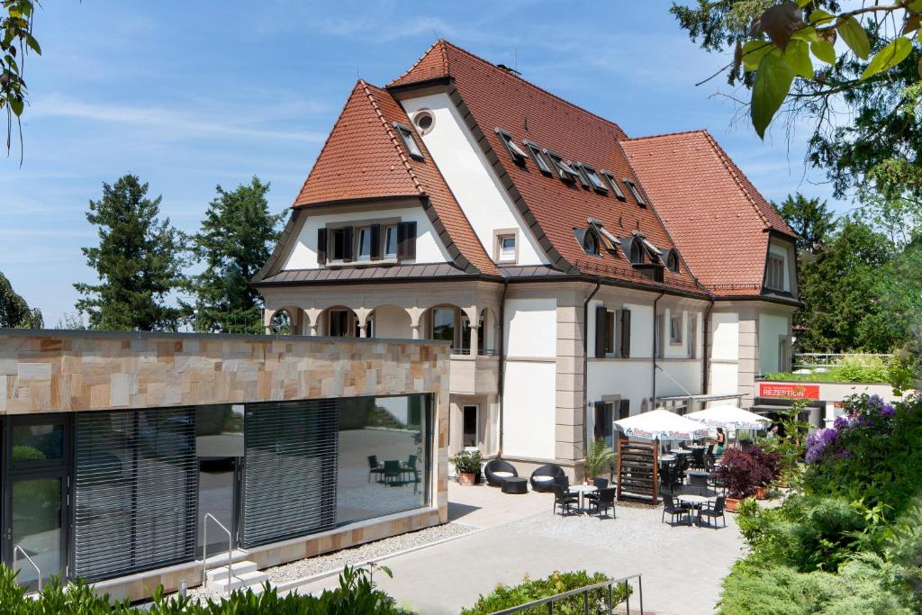 une maison avec un toit rouge et une cour dans l'établissement Caritas Tagungszentrum, à Fribourg-en-Brisgau