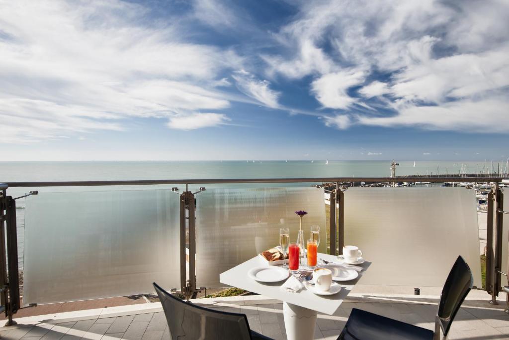 a table on a balcony with a view of the ocean at Smy Aran Blu Roma Mare in Lido di Ostia