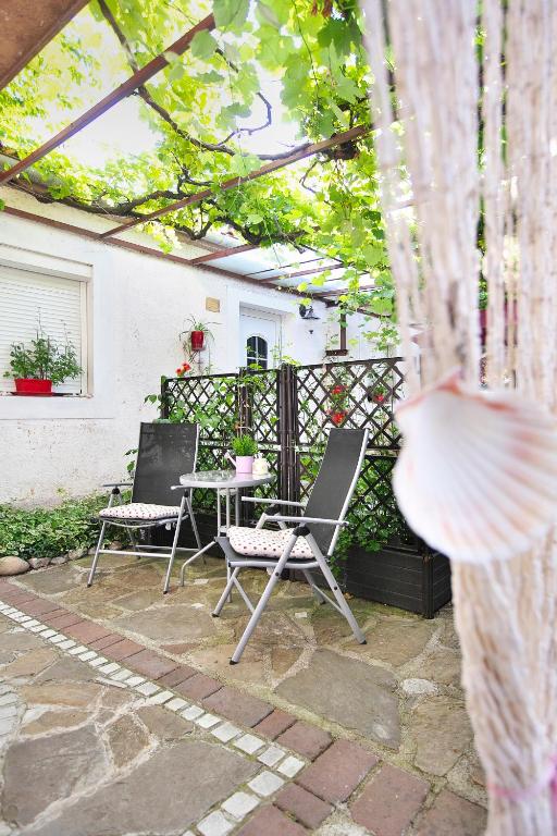 a patio with two chairs and a table and a fence at Apartments Baredi in Izola