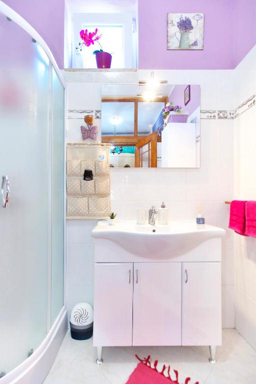 a bathroom with a white sink and a shower at Apartments Baredi in Izola