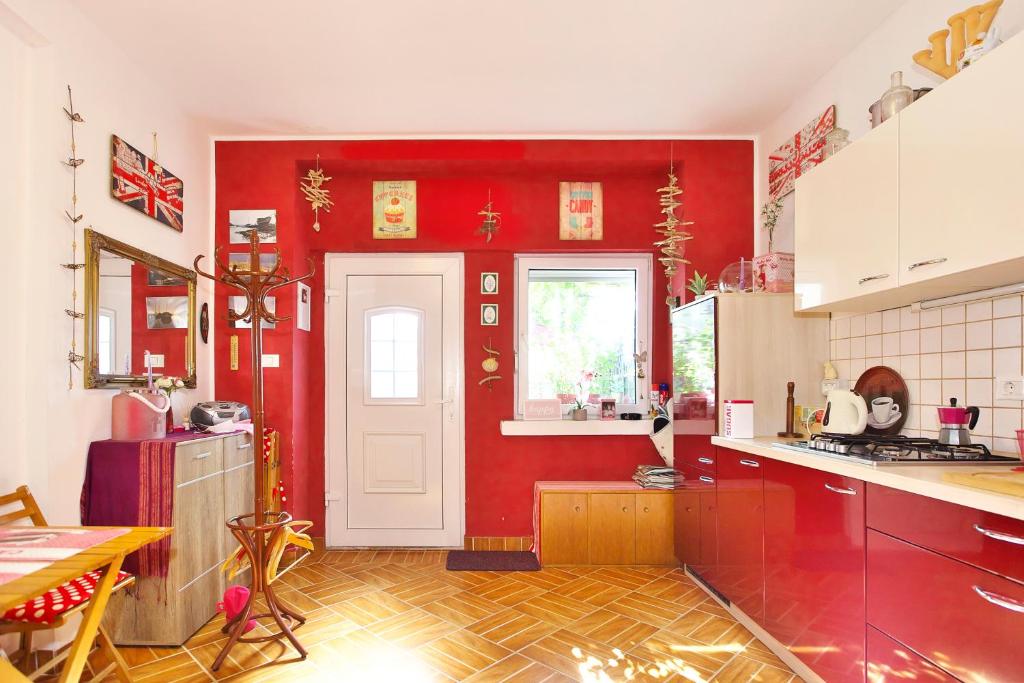 a kitchen with red walls and a white door at Apartments Baredi in Izola