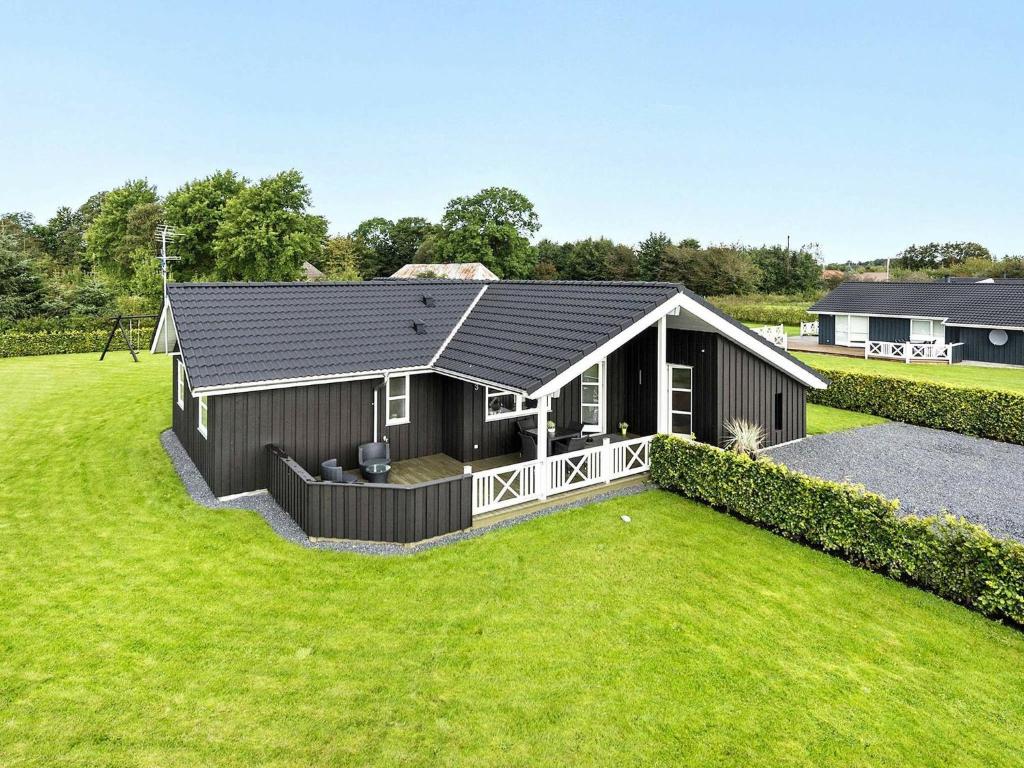uma pequena casa com um grande quintal em frente em Holiday home Hadsund XLIX em Sønder Hurup