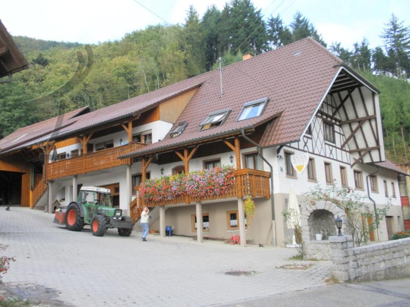 a large building with a tractor in front of it at Vogthof Wohnung Schneckenhus in Lautenbach