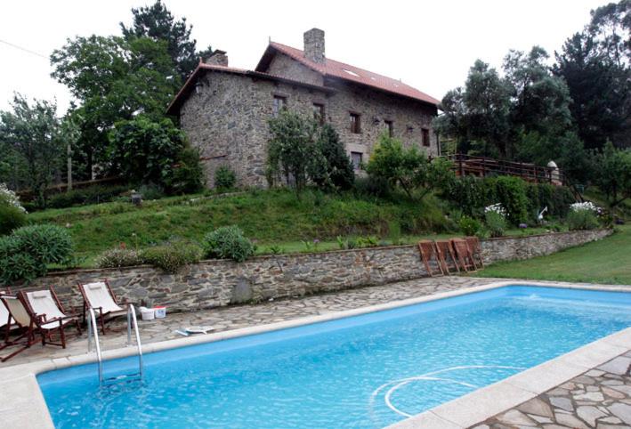 a house with a swimming pool in front of a house at Casa de Sixto in Paderne