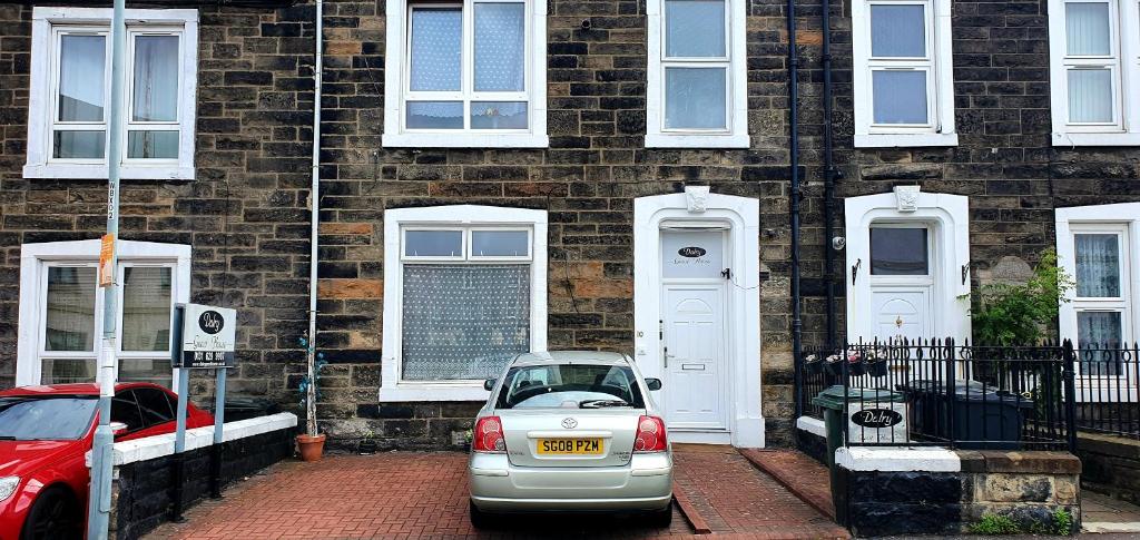 
a white car parked in front of a brick building at Dalry Guesthouse in Edinburgh
