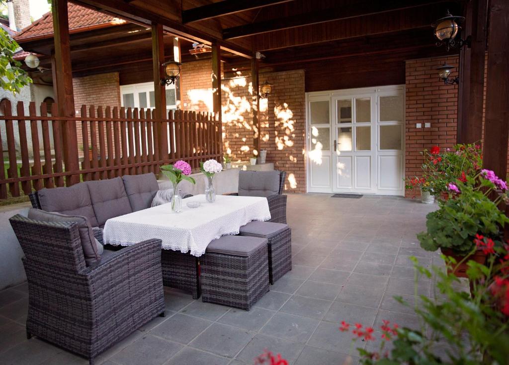 un patio con mesa y sillas de mimbre en Antalóczy Winery&Apartments, en Tokaj