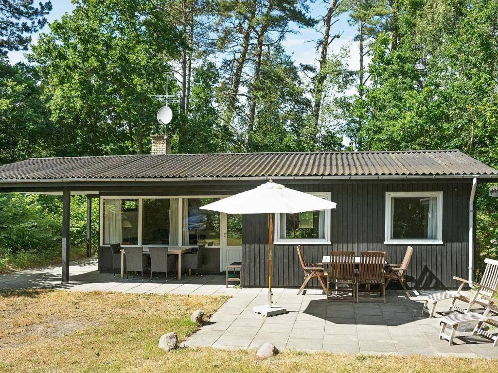 Vester Sømarkenにある4 person holiday home in Aakirkebyの傘とテーブルのある小さな家