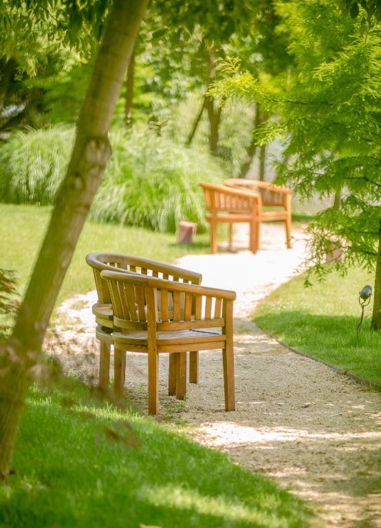 two benches sitting on a path in a park at Caro Hotel in Bucharest