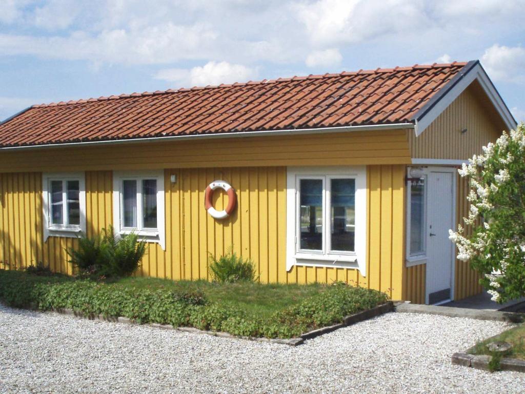 a yellow house with a brown roof at One-Bedroom Holiday home in Stenungsund in Stenungsund