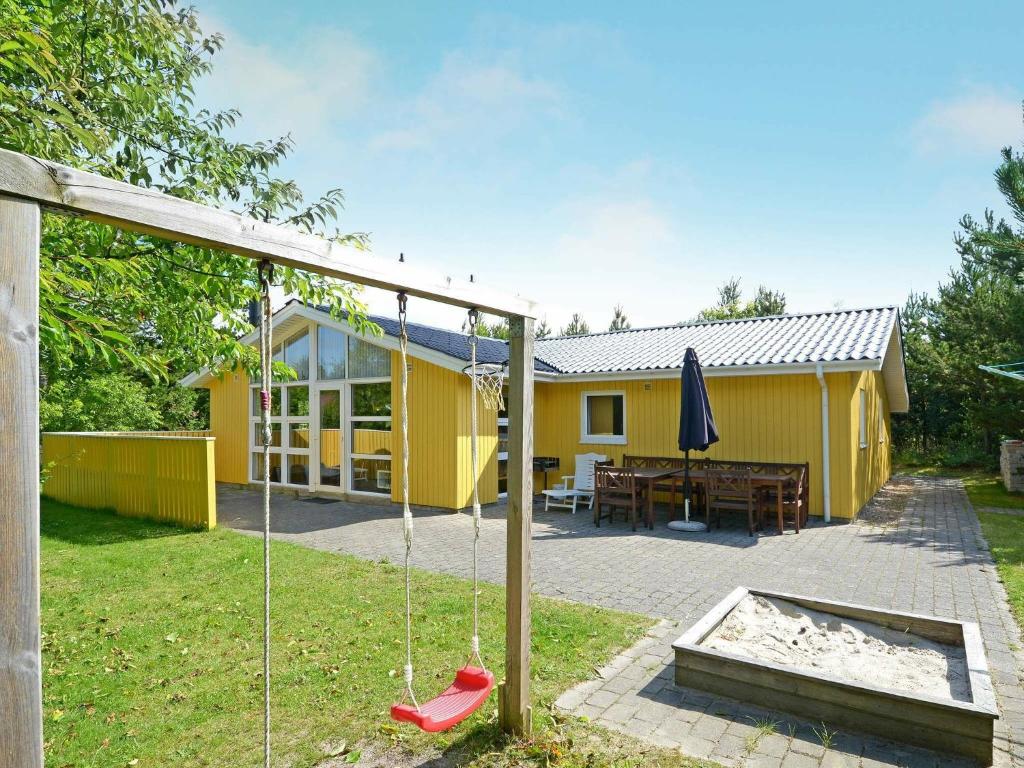 ヘンネ・ストランドにある8 person holiday home in Henneの庭のブランコ付き黄色い家