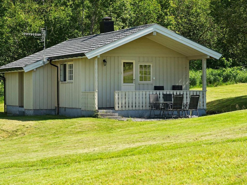 a small white house with a table and chairs at Two-Bedroom Holiday home in Utvik 2 in Reed