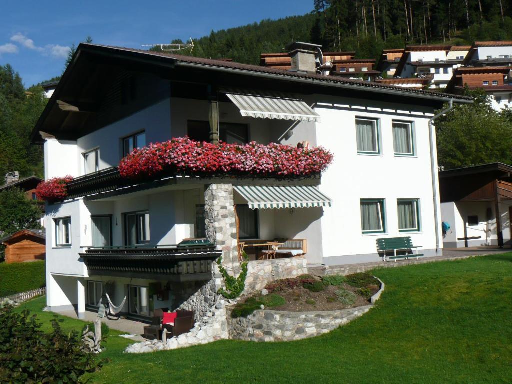 Una casa blanca con flores a un lado. en Haus Saxer, en Mieders