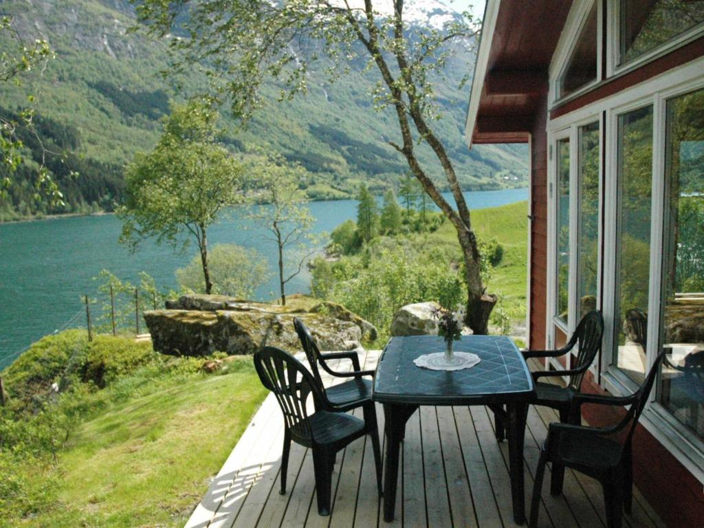 a table and chairs on a porch with a view of a lake at Two-Bedroom Holiday home in Olden 3 in Olden