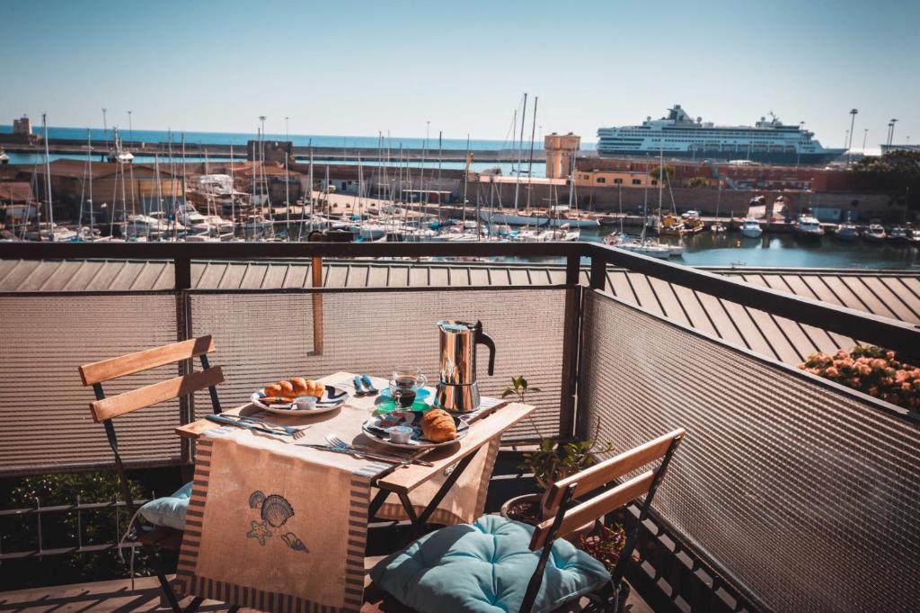 een tafel op een balkon met uitzicht op een haven bij Be Your Home - B&B COLORS in Civitavecchia