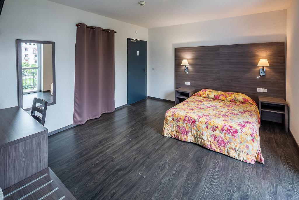 Postel nebo postele na pokoji v ubytování Hôtel Galilée Windsor