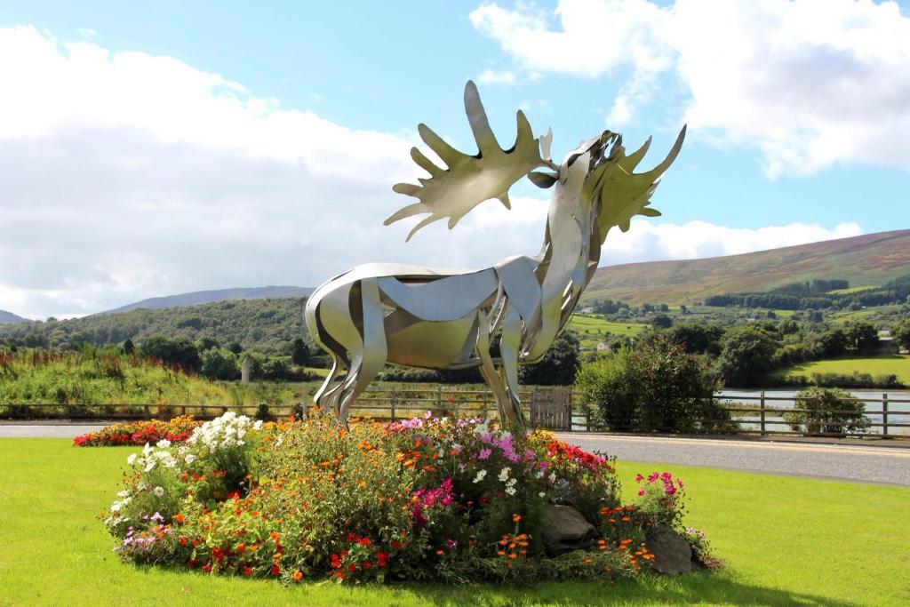 a statue of a deer in a field of flowers at Narrow Water Castle Self Catering Accommodation in Warrenpoint