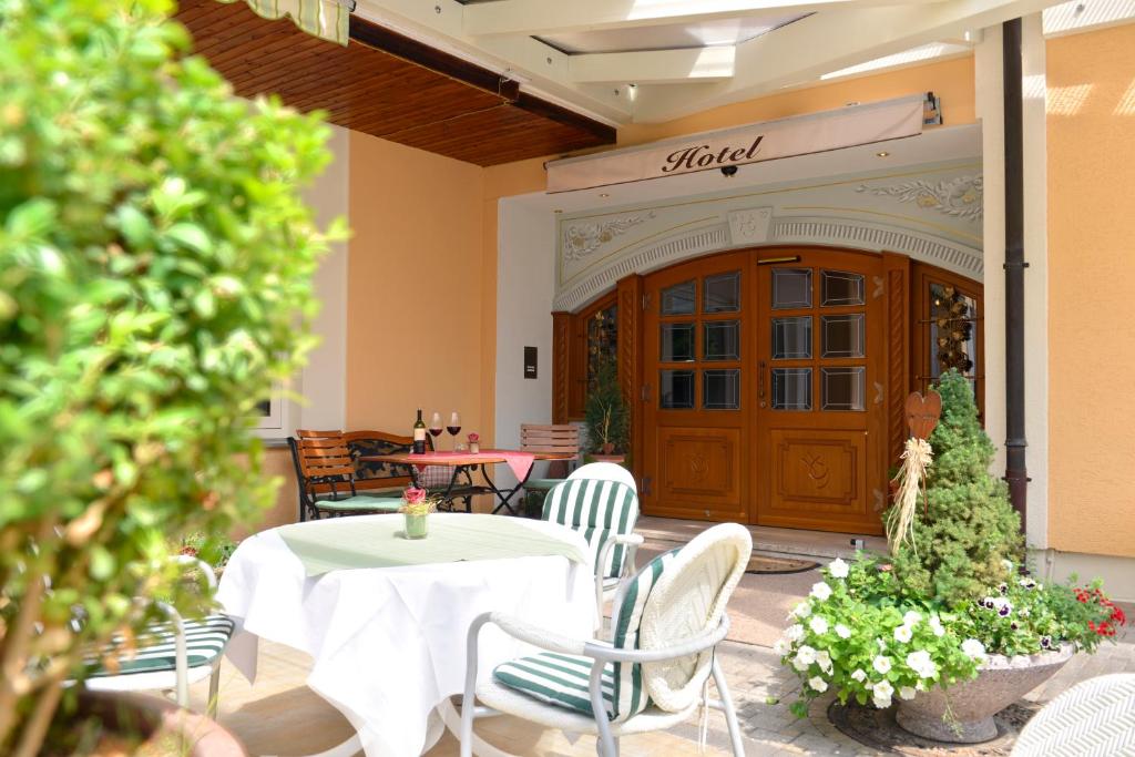 einen Tisch und Stühle vor einem Gebäude in der Unterkunft Hotel Gondel in Altenkunstadt