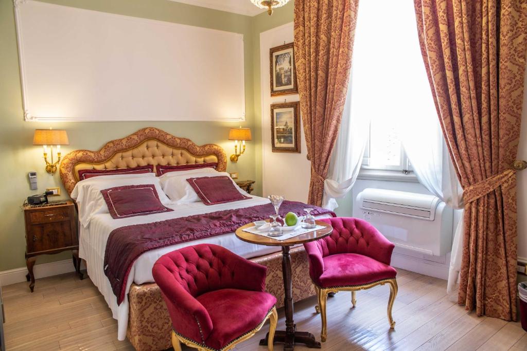 una camera da letto con un letto con un tavolo e due sedie di Stanze del David Place a Firenze