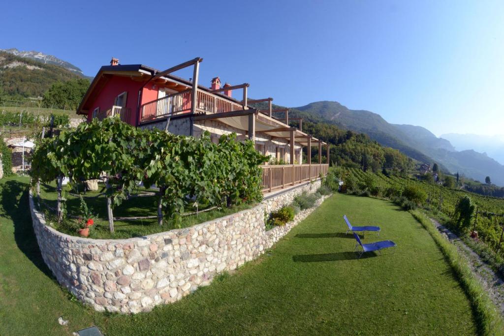 a house on a hill with a stone wall at Agritur Maso Spezial in Villa Lagarina