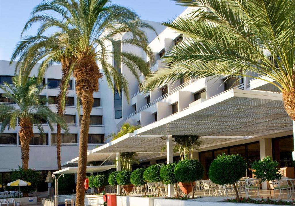ein Hotel mit Palmen davor in der Unterkunft Lagoona by Isrotel Collection in Eilat