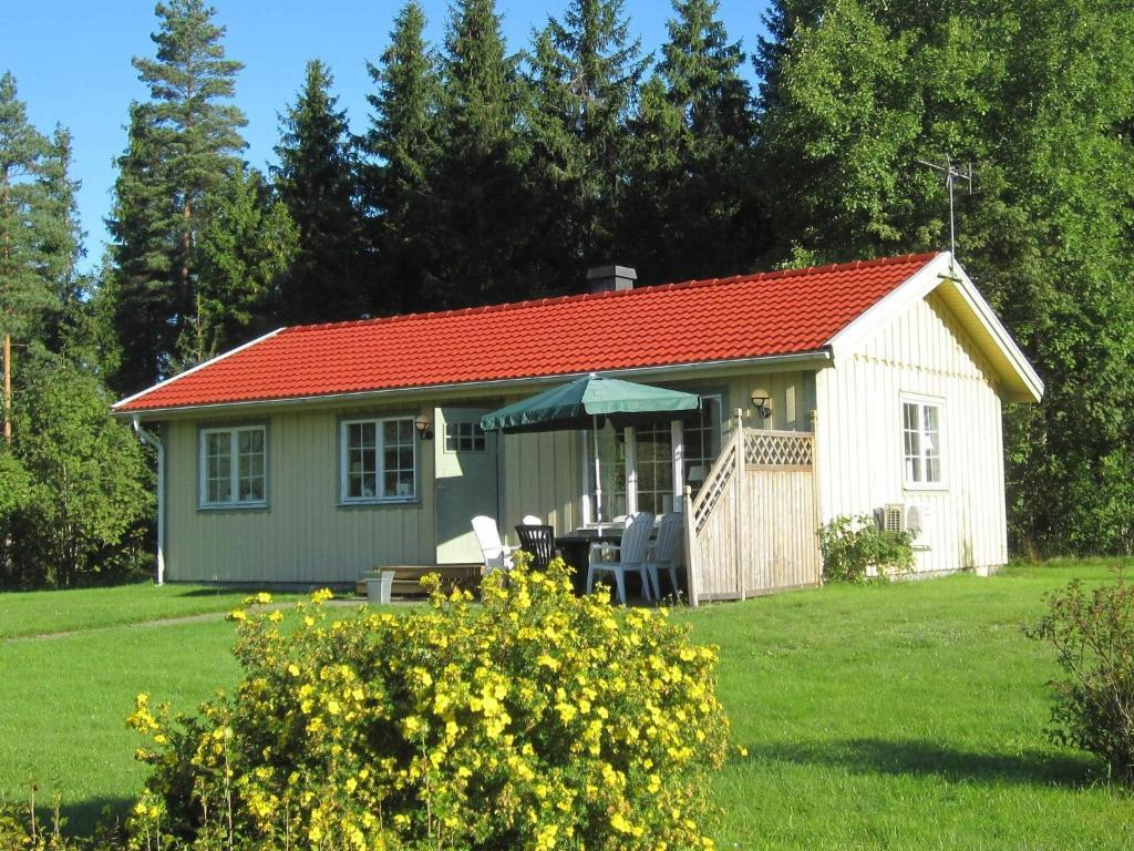 um pequeno chalé branco com um telhado vermelho em Two-Bedroom Holiday home in Håcksvik 2 em Håcksvik