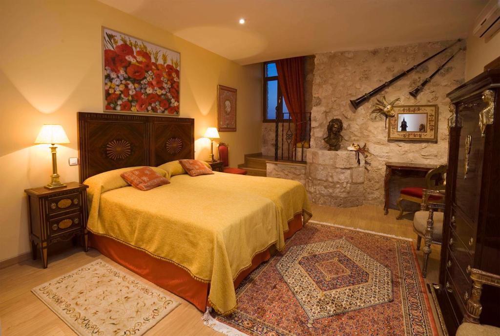 a bedroom with a bed and a stone fireplace at Residencia Real del Castillo de Curiel in Curiel de Duero