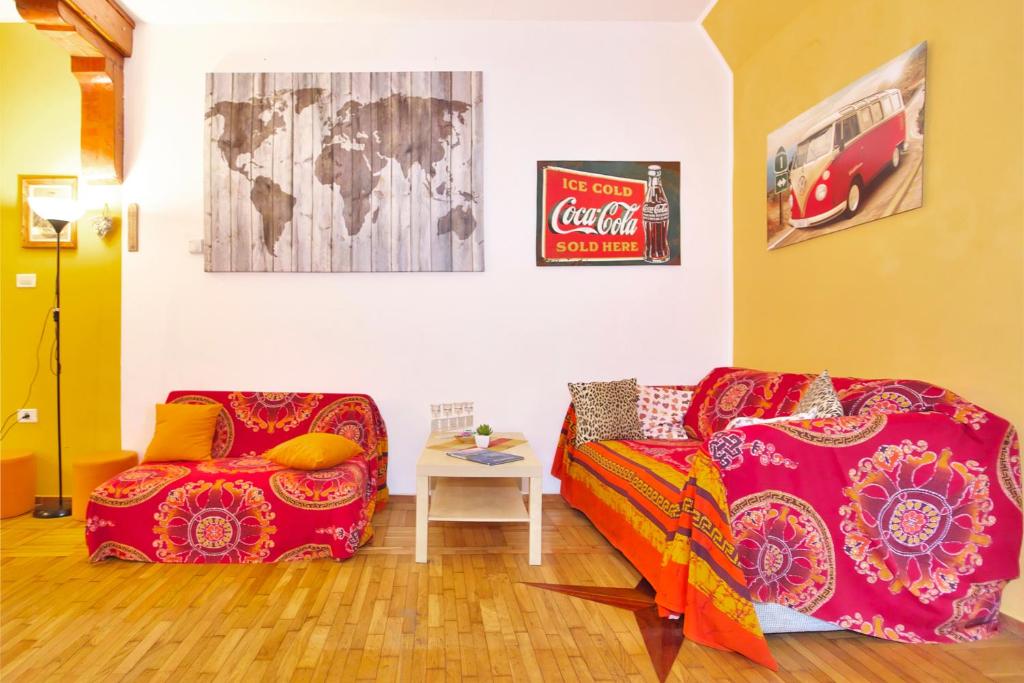 a living room with two red couches and a cocacola at Apartments Baredi in Izola