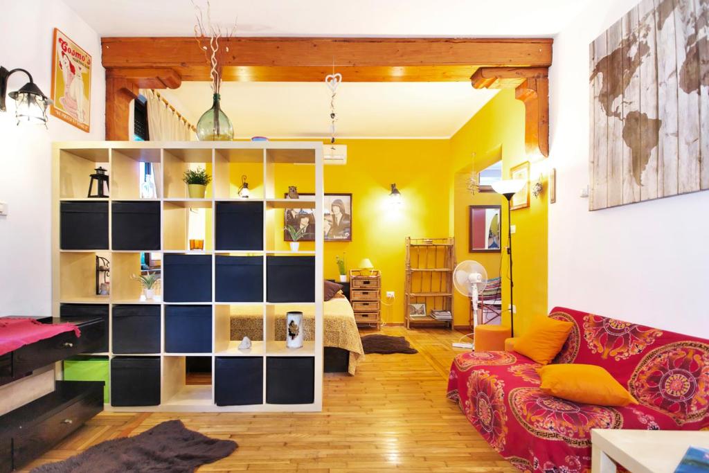a living room with a red couch and yellow walls at Apartments Baredi in Izola