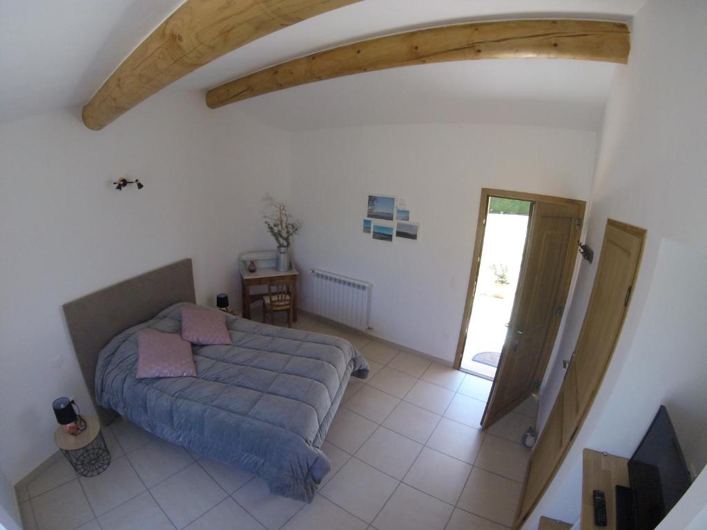 a living room with a bed and a doorway at LA MAGUETTE in Sault-de-Vaucluse