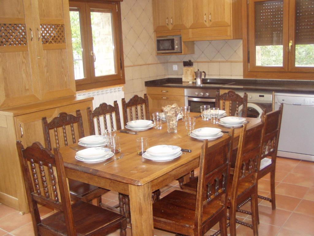a kitchen with a wooden table with chairs and a tableablish at Nekasenea II in Garísoain