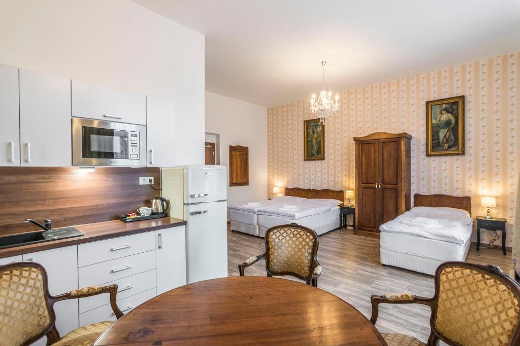 eine Küche und ein Esszimmer mit 2 Betten und einem Tisch in der Unterkunft RETRO Apartments Bosak in Prešov