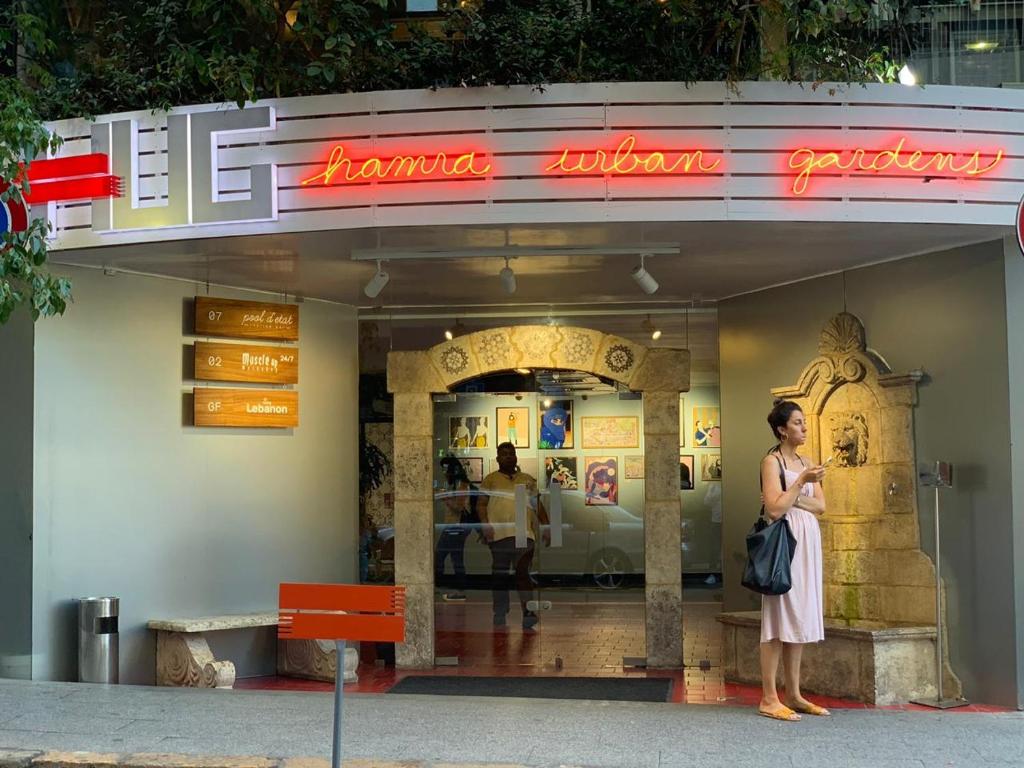 a woman standing in front of a restaurant at Hamra Urban Gardens in Beirut