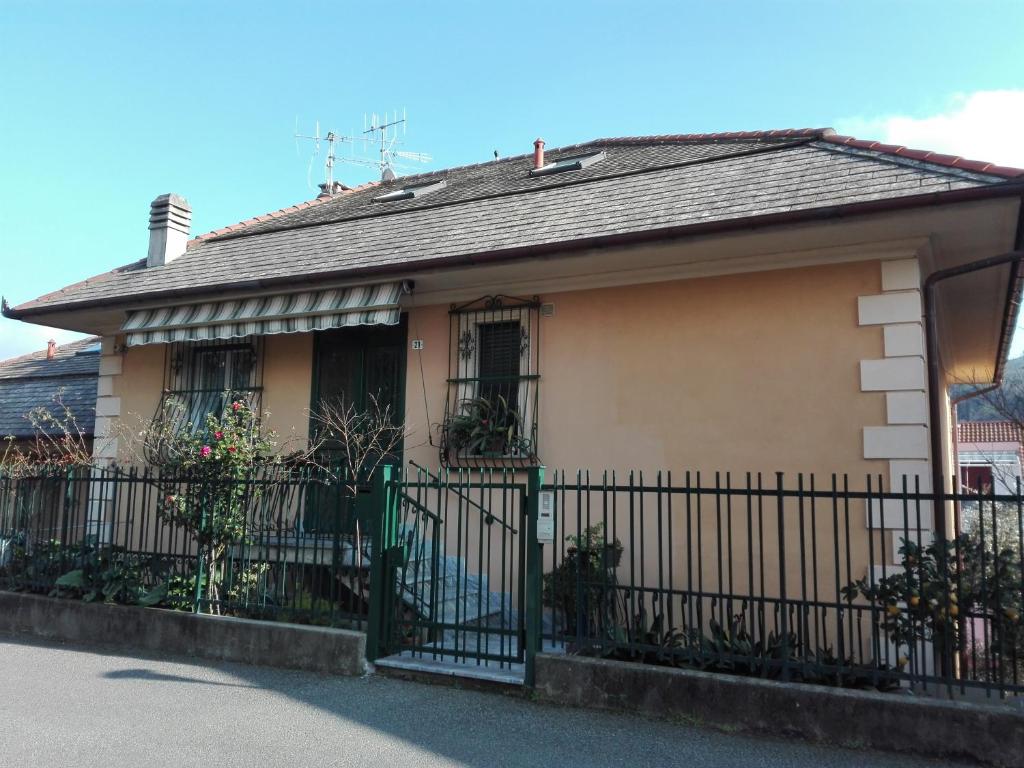 una pequeña casa con una valla verde en La Casa del Geco, en Casarza Ligure