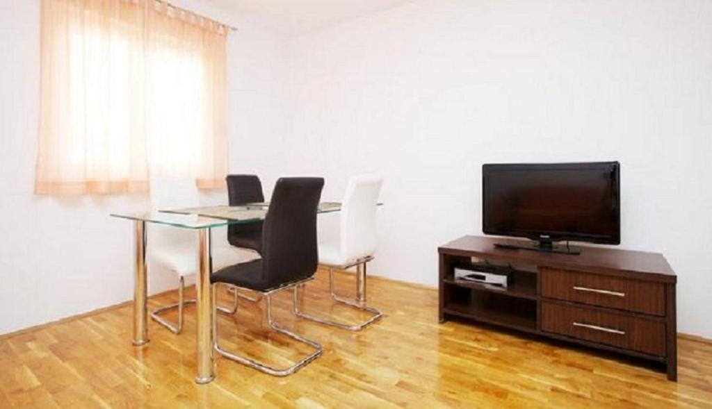 Televízia a/alebo spoločenská miestnosť v ubytovaní Apartments and Rooms Mišić