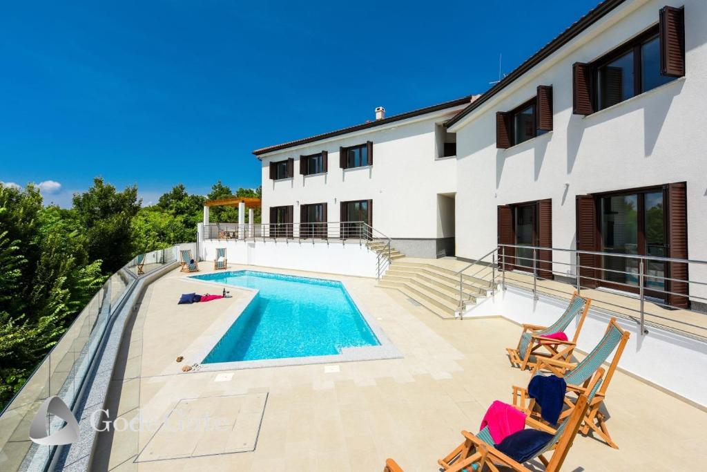 uma villa com piscina e 2 cadeiras em Villa Lubey em Ljubac