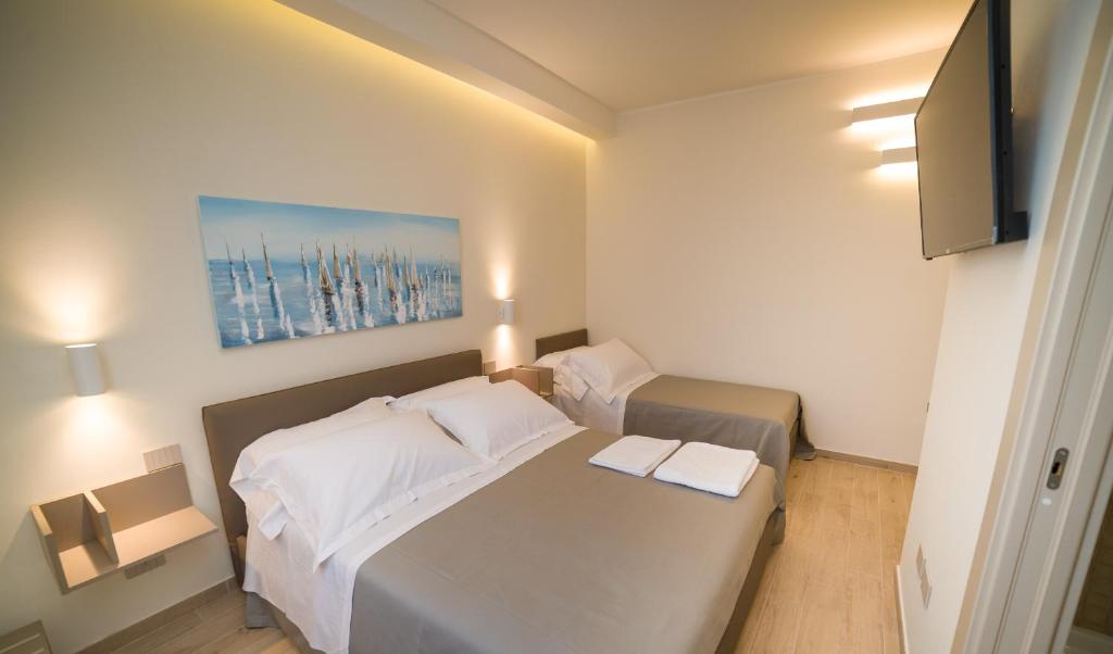 een kleine slaapkamer met 2 bedden en een televisie bij kamilia guestrooms in San Cassiano