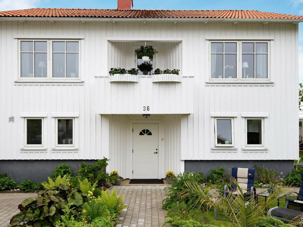 Casa blanca con puerta y ventanas blancas en One-Bedroom Holiday home in Lysekil 11, en Lysekil