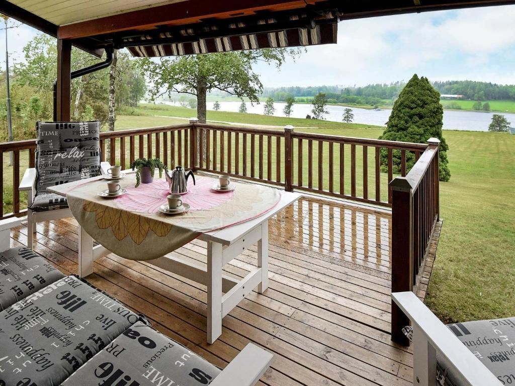 une terrasse en bois avec une table et des chaises. dans l'établissement Two-Bedroom Holiday home in Frändefors 1, à Stora Lövnäs