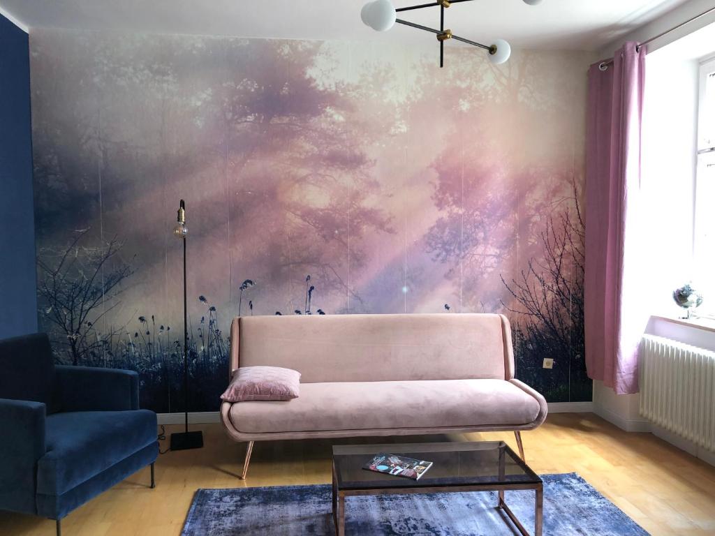 un soggiorno con divano rosa e un dipinto di Luna Estela a Bayreuth